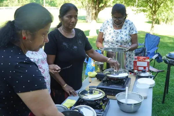 People cooking together at an outdoor food station
