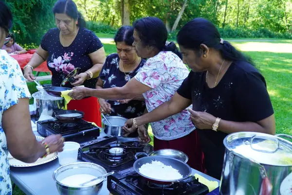 People cooking together at an outdoor table