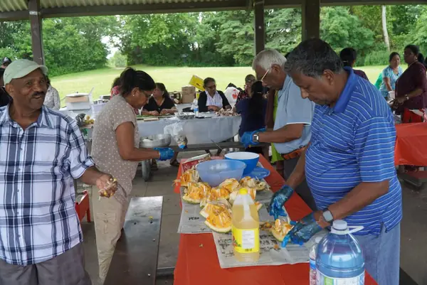 People serving food under a pavilion