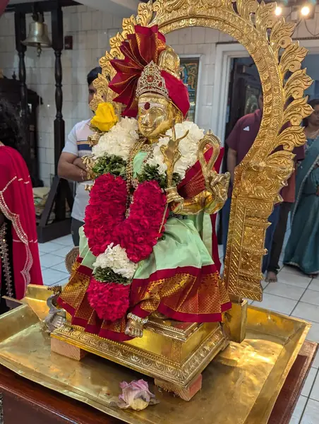 Decorated statue of a deity adorned with red flowers