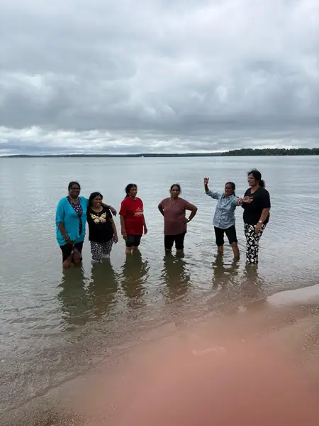 People wading in shallow water at a beach