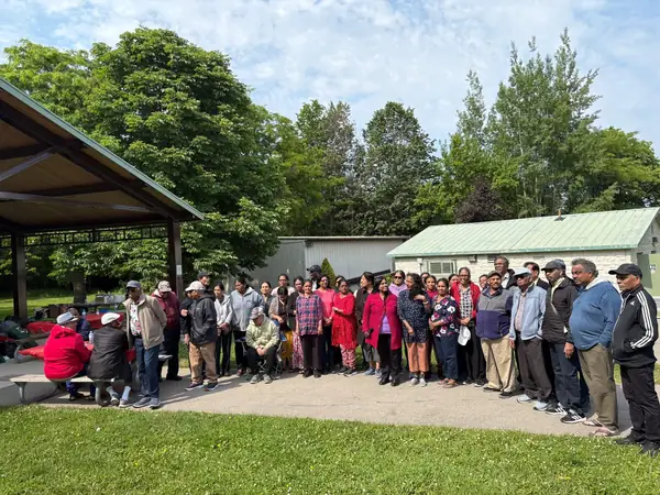 Large group posing in front of a park building