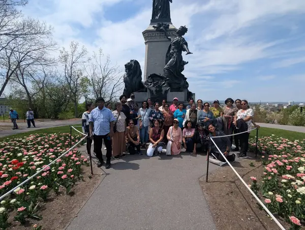 People on a path between tulip beds near a monument