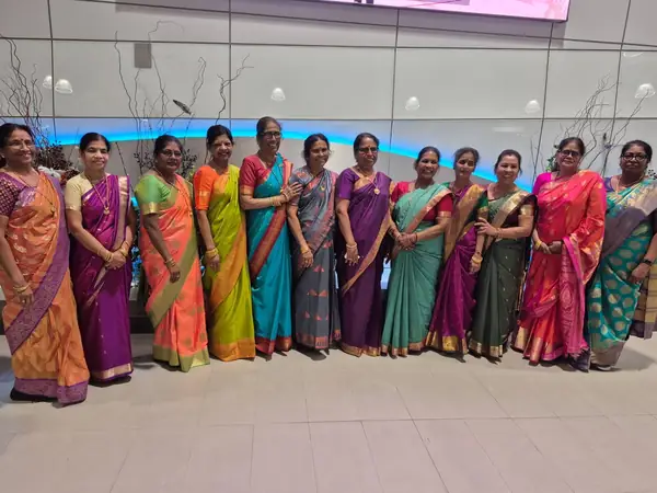 Row of women in matching saris standing indoors
