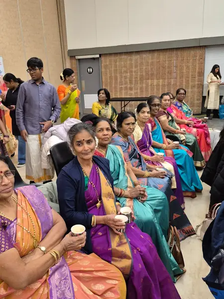 Women in saris seated in a row indoors