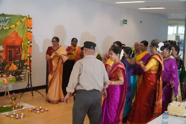 People gathered indoors beside a festive display