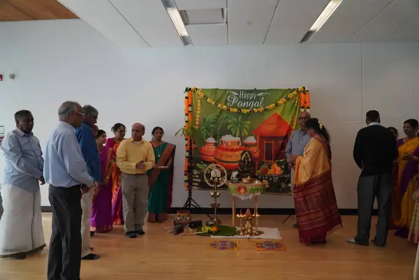People gathered beside a festive display in a hall