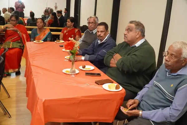 People seated at a table with an orange tablecloth