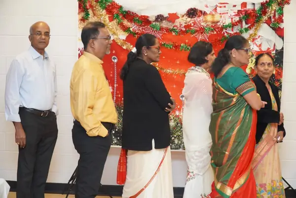 People standing in front of a red and gold backdrop