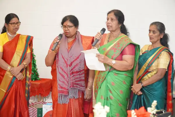 Women in saris speaking into a microphone