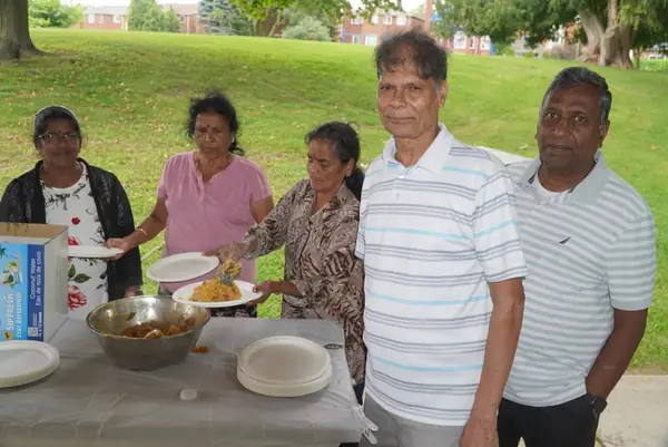 People standing by a table of food outdoors