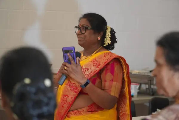A woman in a sari holding a phone at an event