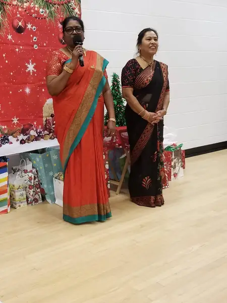 Two women speaking in front of a festive display