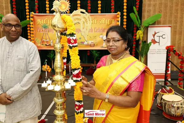 A woman lighting a traditional brass lamp