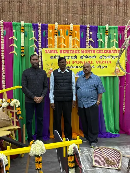 People standing in front of a decorated stage with a banner